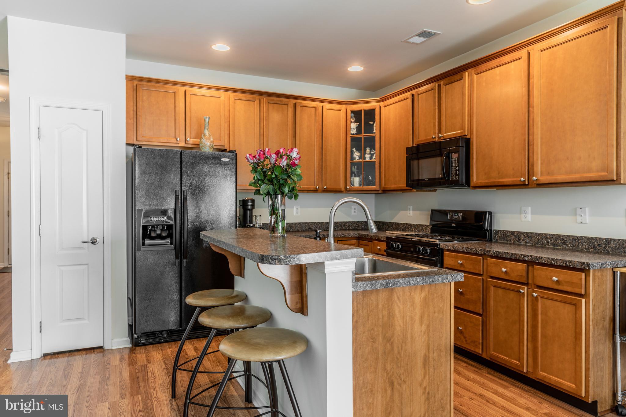 108 Eagleview Terrace Mount Royal, NJ 08061 - Photo 8 of 24 a kitchen with stainless steel appliances granite countertop a refrigerator a stove a sink cabinets and a dining table with wooden floor