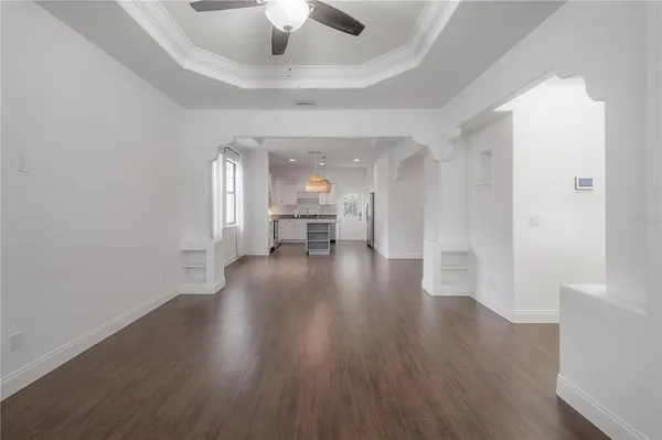 a view of a hallway with wooden floor a chandelier