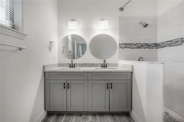 a bathroom with a double vanity sink and a mirror