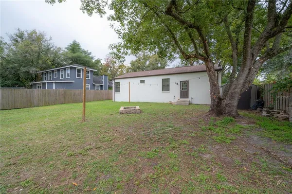 a view of a house with backyard and a tree