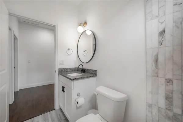 a bathroom with a toilet a sink and a mirror