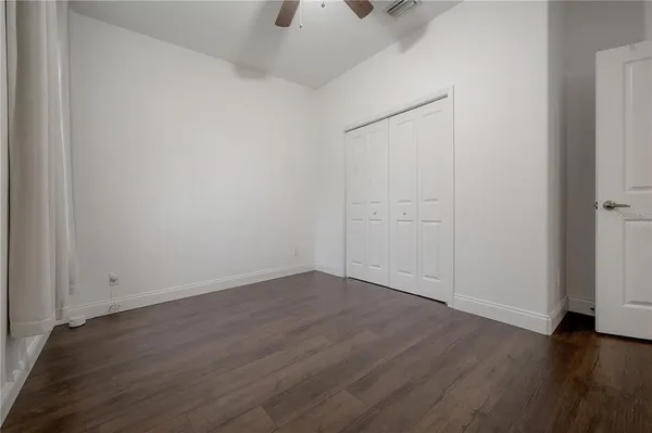 an empty room with wooden floor and closet