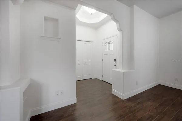an empty room with wooden floor and mirror