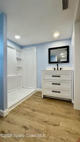 a view of a hallway with closet and wooden floor