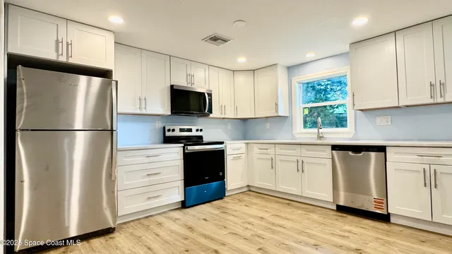 a kitchen with stainless steel appliances granite countertop a refrigerator stove a sink and a microwave