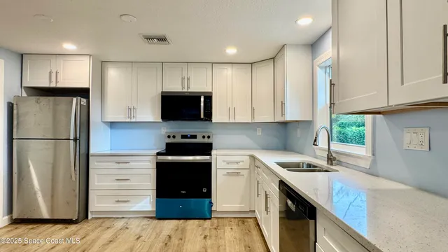 a kitchen with stainless steel appliances a refrigerator stove and sink