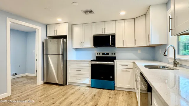 a kitchen with stainless steel appliances granite countertop a stove a sink and a microwave