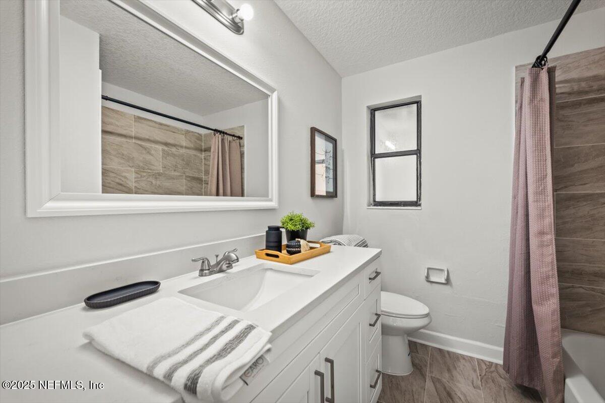2905 Sandhurst Road East Jacksonville, FL 32277 - Photo 19 of 28 a bathroom with a sink a toilet and mirror