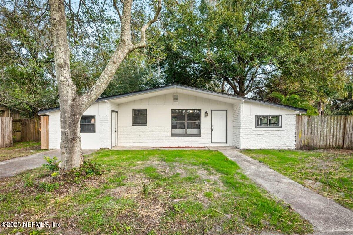 2905 Sandhurst Road East Jacksonville, FL 32277 - Photo 2 of 28 a view of a yard in front of a house with large trees