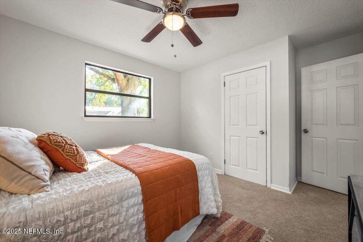 2905 Sandhurst Road East Jacksonville, FL 32277 - Photo 23 of 28 a bedroom with a bed and a chandelier
