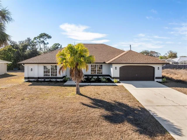 a front view of a house with yard and garage