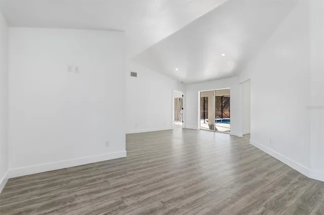 a view of empty room with wooden floor