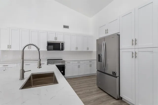 a kitchen with a refrigerator a stove a microwave and cabinets