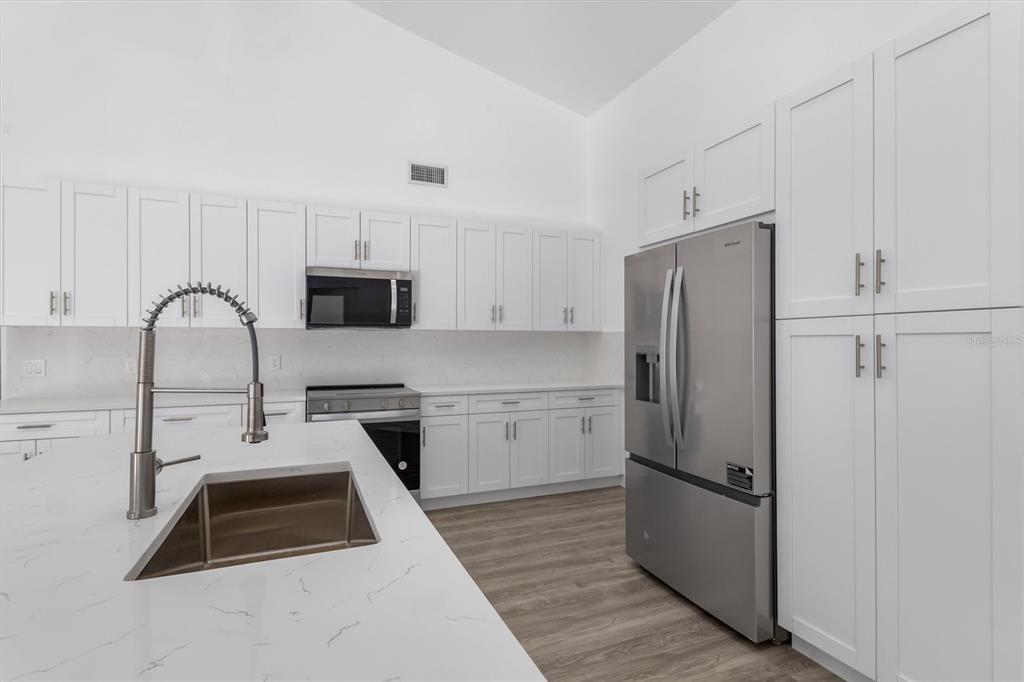 375 Waterside Street Port Charlotte, FL 33954 - Photo 16 of 49 a kitchen with a refrigerator a stove a microwave and cabinets