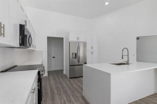 a kitchen with a sink and wooden floor
