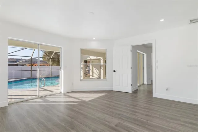 an empty room with wooden floor and window