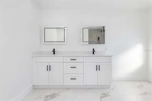 a bathroom with double sink and a mirror