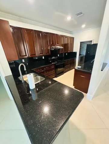a kitchen with granite countertop a refrigerator and stove