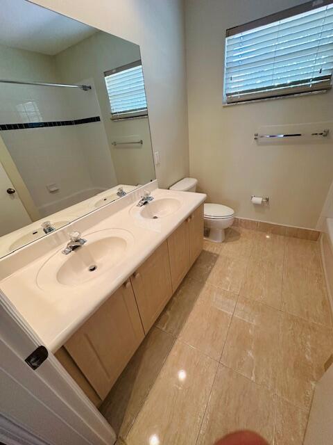 5245 Sancerre Circle Lake Worth, FL 33463 - Photo 40 of 46 a bathroom with a sink a toilet and mirror
