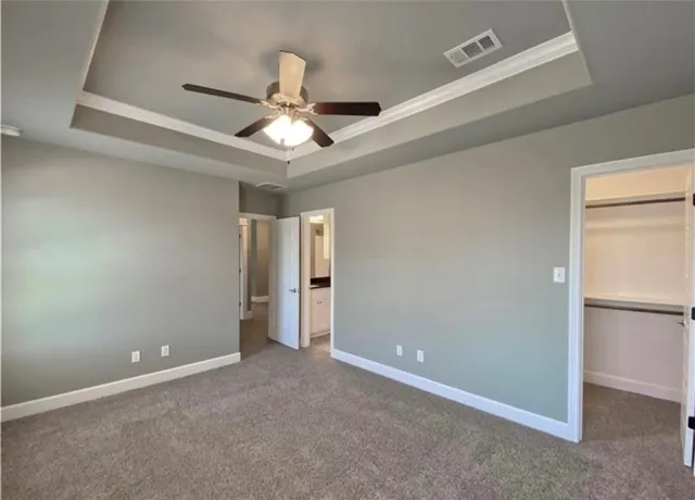 an empty room with closet and a ceiling fan