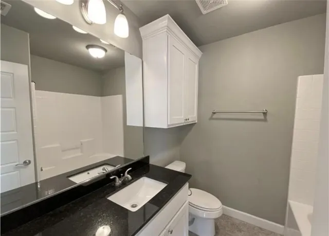 a bathroom with a sink a toilet and a mirror