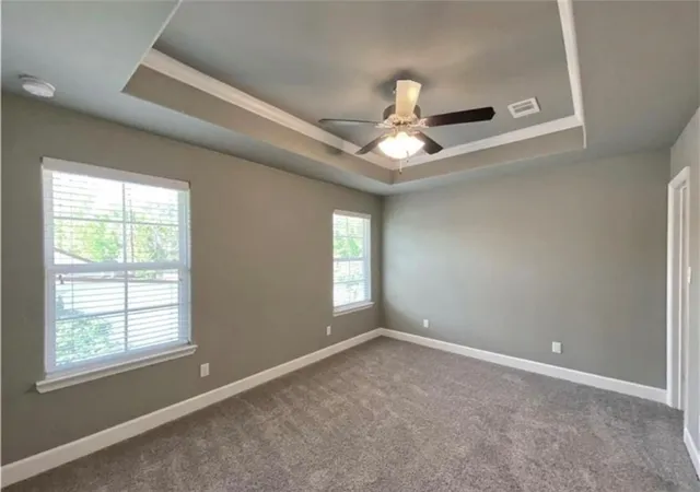 an empty room with windows and ceiling fan