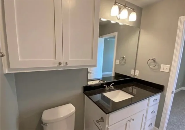 a bathroom with a sink a toilet and a mirror