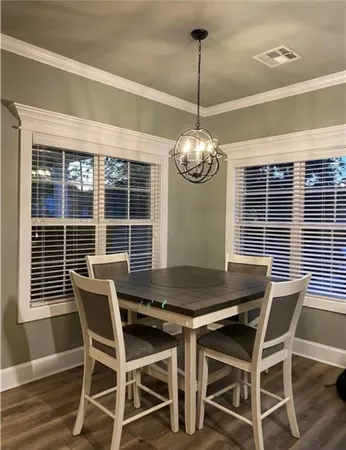 a view of a dining room with furniture wooden floor and chandelier