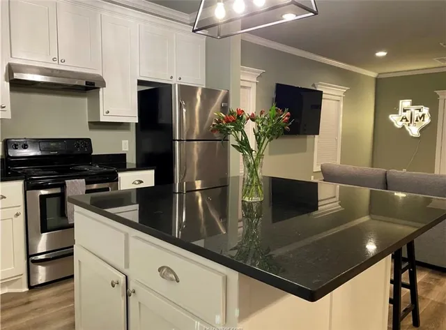 a kitchen with stainless steel appliances granite countertop a refrigerator a stove and a refrigerator