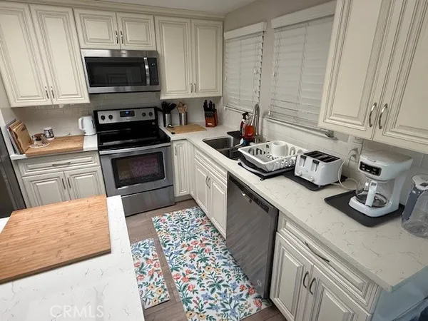 a kitchen with stainless steel appliances granite countertop a sink stove and cabinets