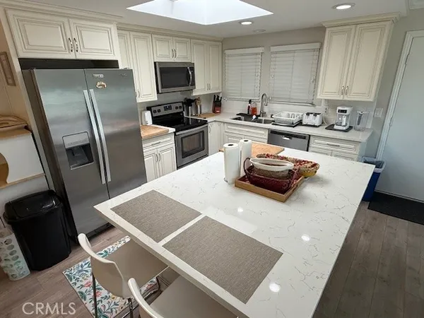a kitchen with stainless steel appliances a refrigerator sink stove microwave and cabinets