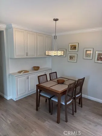 a kitchen with a dining table chairs and white cabinets