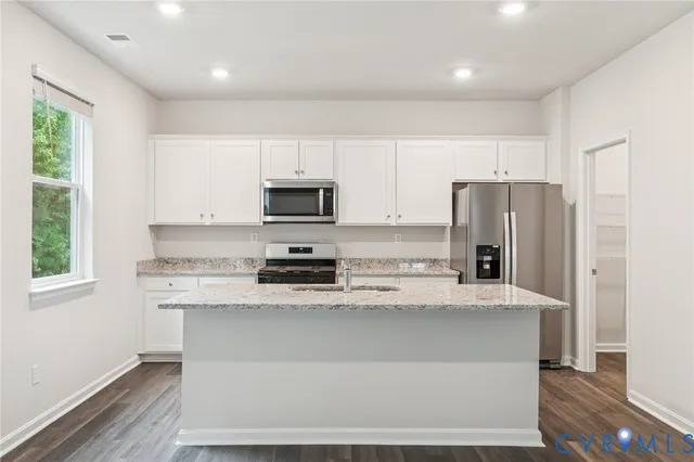 a kitchen with kitchen island a refrigerator sink and microwave