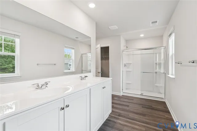 a spacious bathroom with a shower sink and mirror