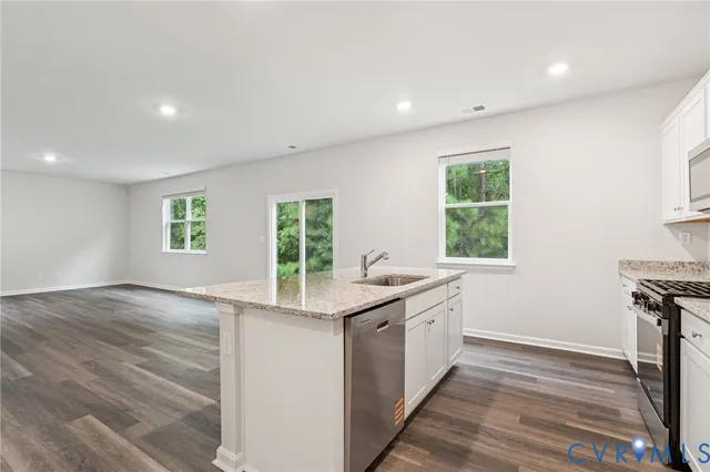 a kitchen with granite countertop a stove and a wooden floors