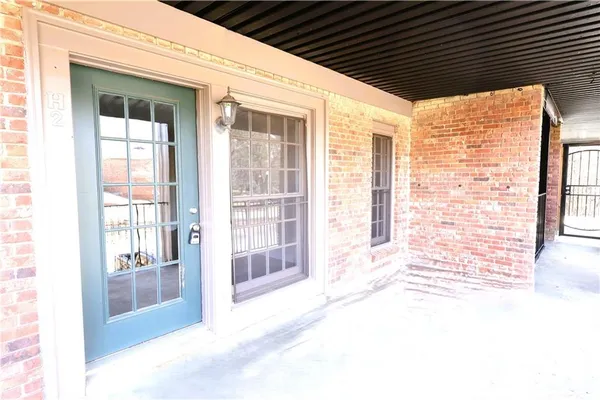 a view of a porch with a table and chairs and floor to ceiling window