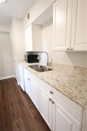 a kitchen with granite countertop white cabinets and white appliances