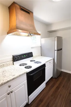 a kitchen with a stove cabinets and wooden floor