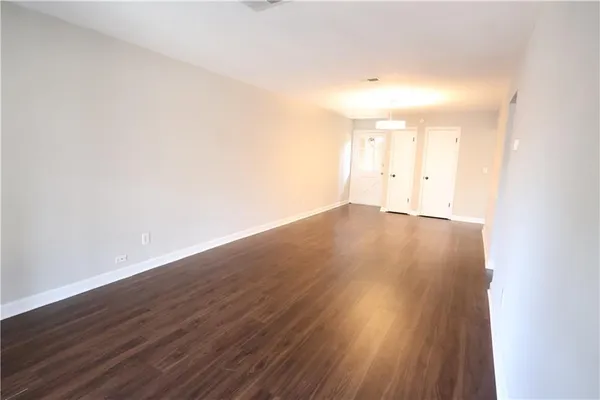 a view of an empty room and wooden floor