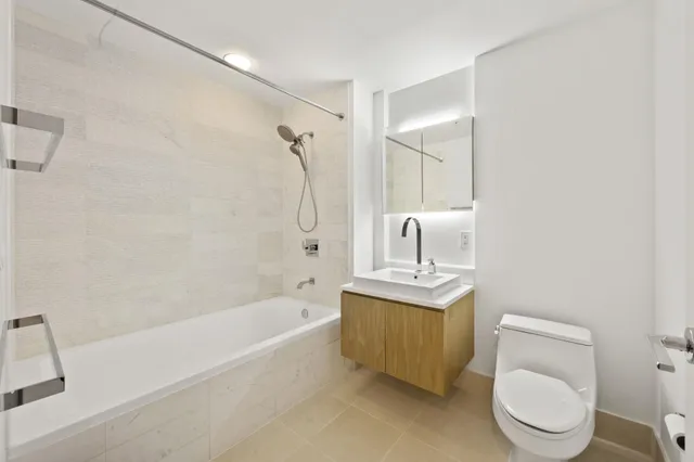 a bath room with a toilet sink and a bath tub