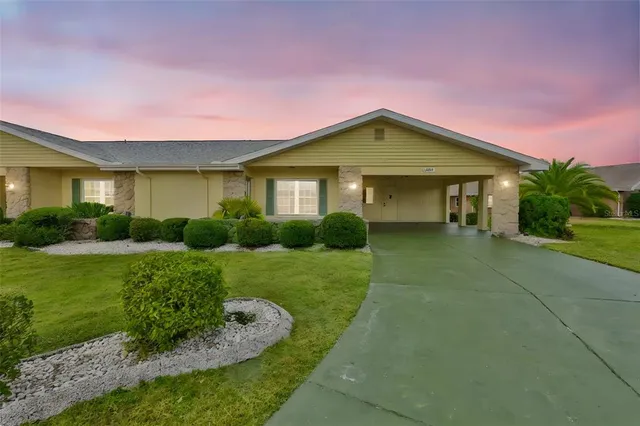 a front view of a house with a yard and potted plants
