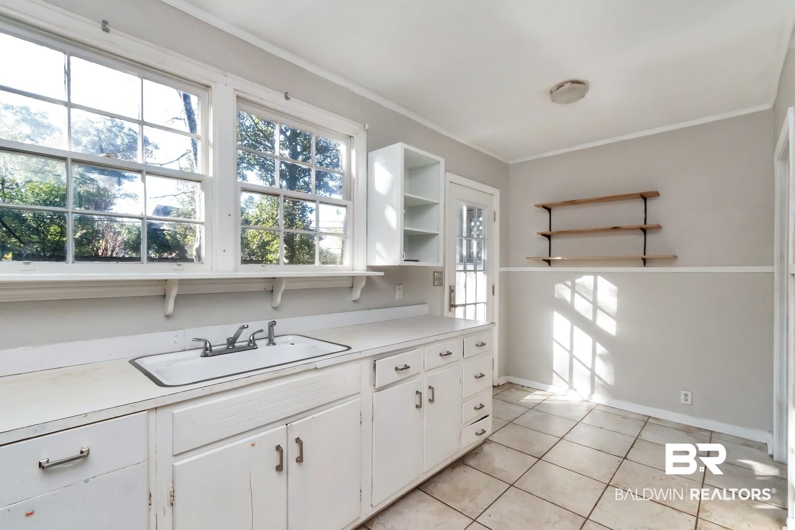 5001 Hillwood Circle South Mobile, AL 36608 - Photo 9 of 20 Kitchen with a sink, white cabinets, light countertops, open shelves, and crown molding