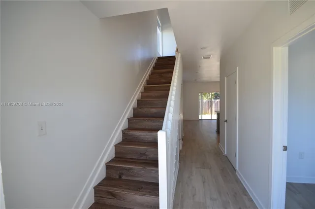 a view of entryway and hall with wooden floor