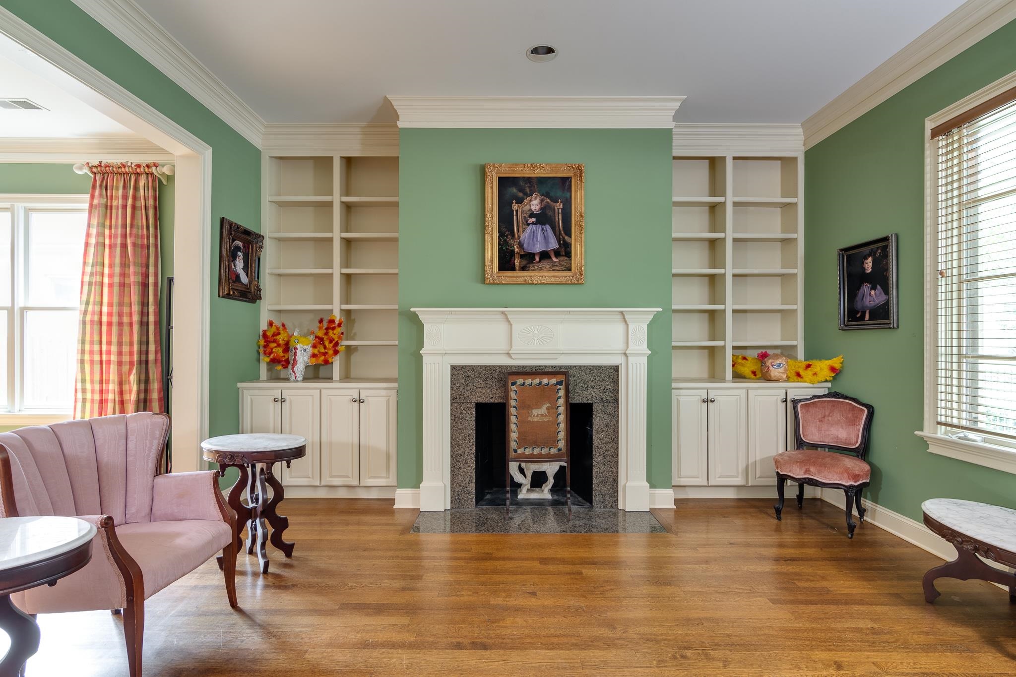 Living area featuring a premium fireplace, built in features, hardwood / wood-style flooring, and a wealth of natural light