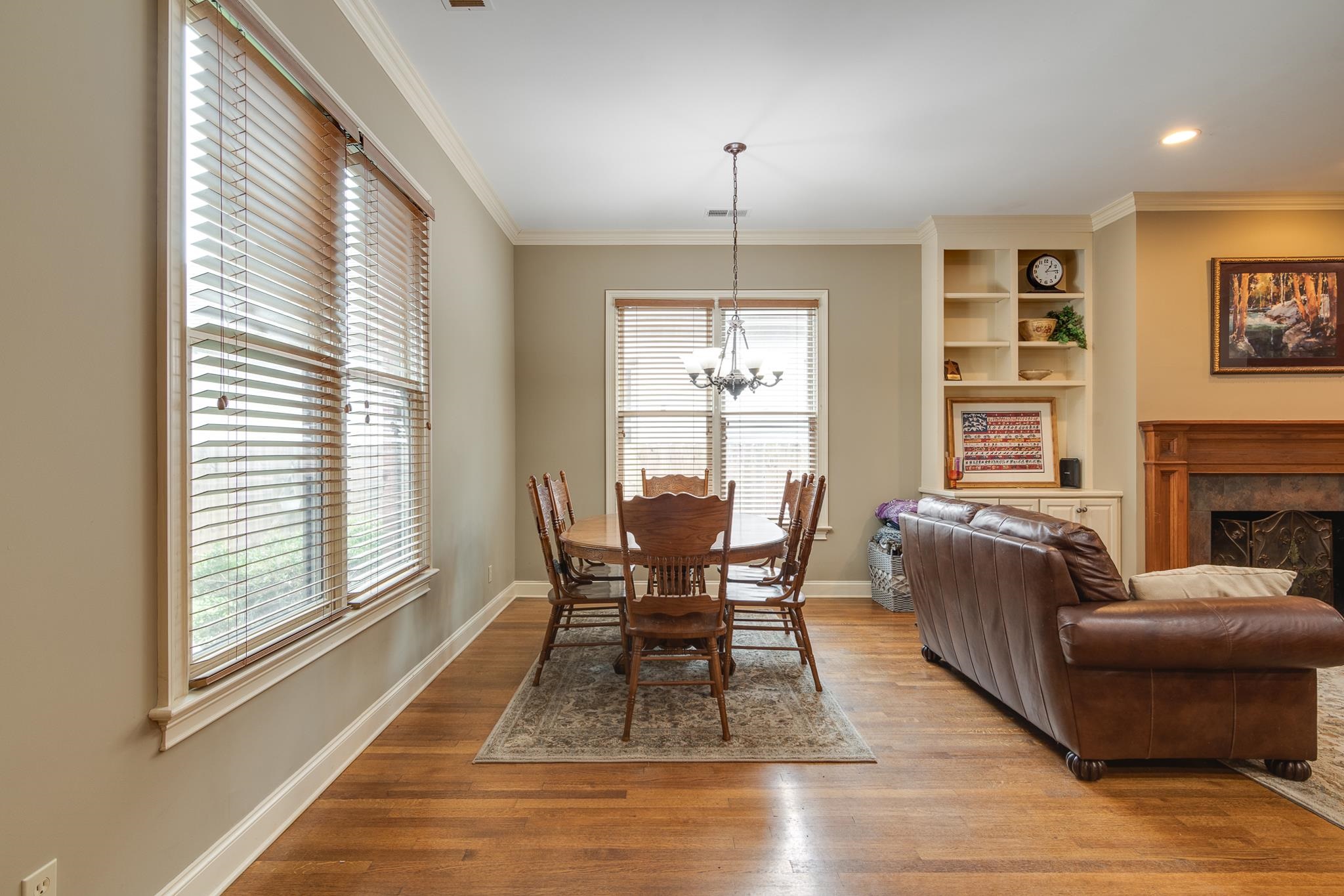 226 North White Station Road Memphis, TN 38117 - Photo 12 of 31 Dining area featuring ornamental molding, wood-type flooring, built in shelves, and an inviting chandelier