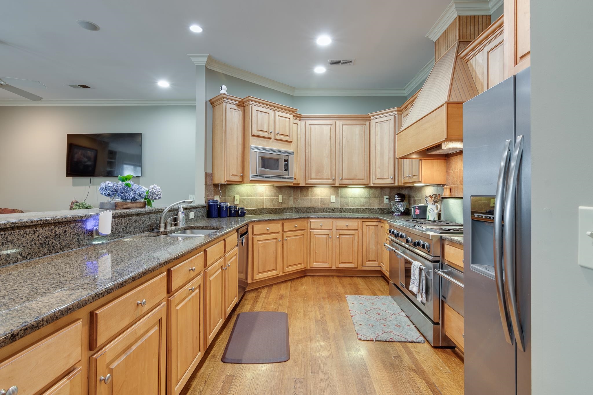 226 North White Station Road Memphis, TN 38117 - Photo 14 of 31 Kitchen featuring light hardwood / wood-style floors, ornamental molding, stainless steel appliances, backsplash, and sink