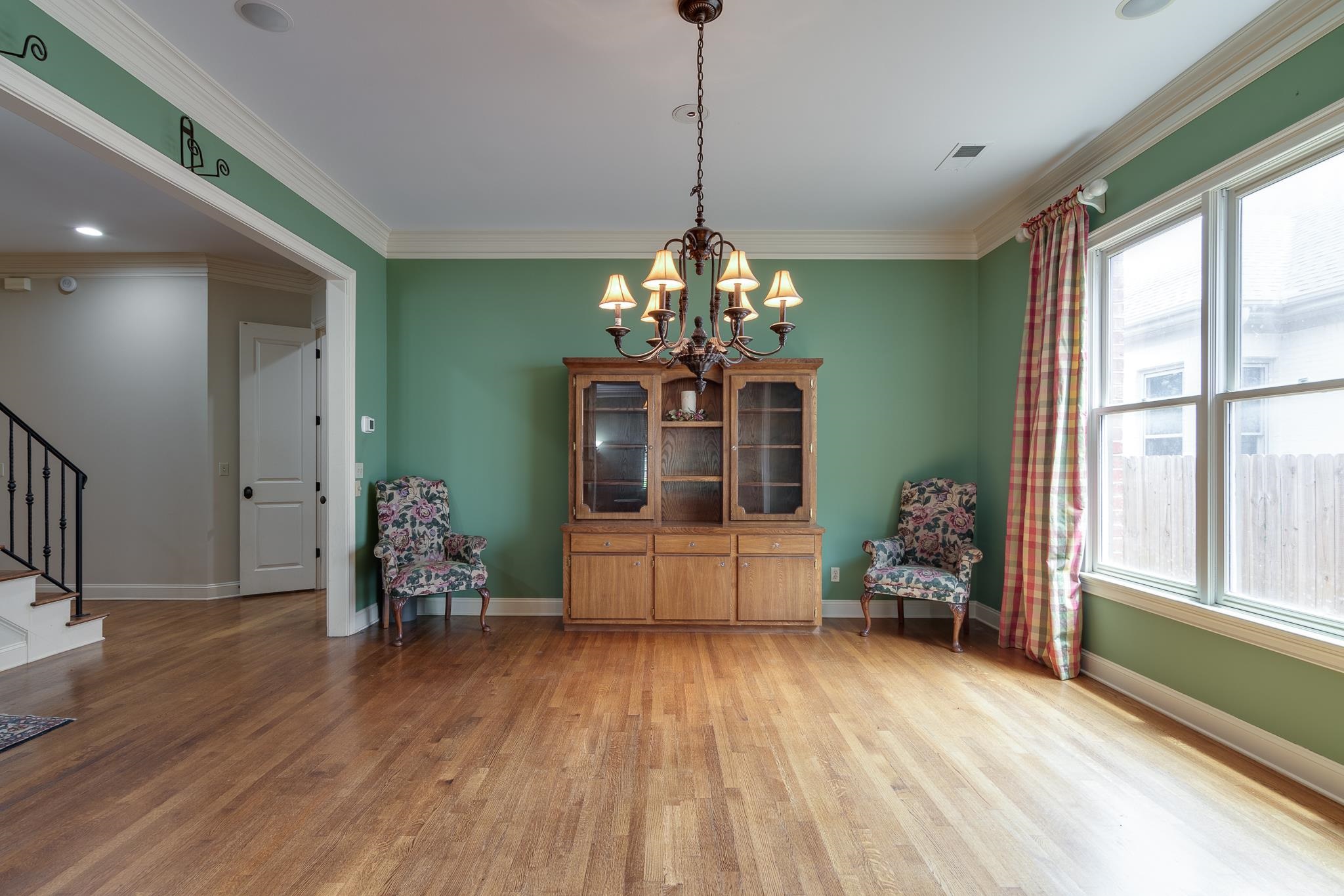 226 North White Station Road Memphis, TN 38117 - Photo 4 of 31 Unfurnished room with a wealth of natural light, ornamental molding, light wood-type flooring, and a chandelier