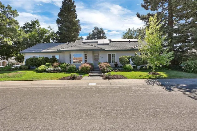 a view of a house with a yard and potted plants