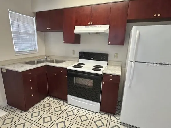 a kitchen with stainless steel appliances wooden cabinets and a stove