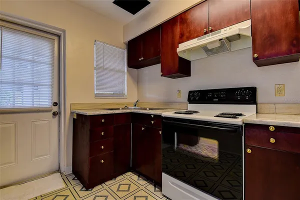 a view of kitchen with stainless steel appliances granite countertop a refrigerator and a stove